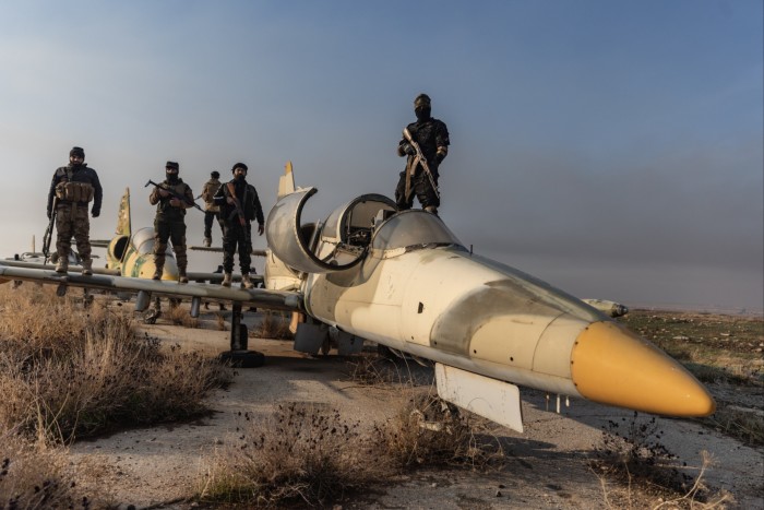 Члены сирийской вооруженной оппозиции на крыше военного самолета после захвата военного аэропорта Найраб в городе Алеппо