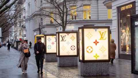 Покупатели проходят мимо магазина Louis Vuitton в Берлине.