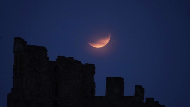 Частичное лунное затмение видно над Priory Tynemouth в 2019 году. PIC: PA