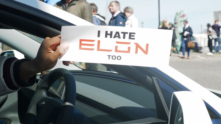Владелец Tesla держит этот знак в дилерском центре в Западном Лондоне.