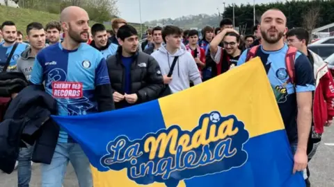 Wycombe Wanderers Группа испанских поклонников, идущих на футбольный матч Wycombe Wanderers, в то время как держит флаг. "LA Media Inglesa"