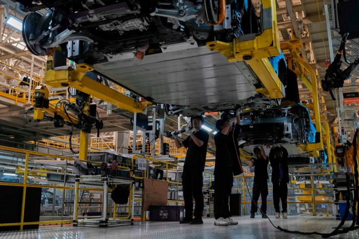 Рабочие собирают электромобили на заводе Zeekr Assembly в Нинбо в восточной провинции Чжэцзян