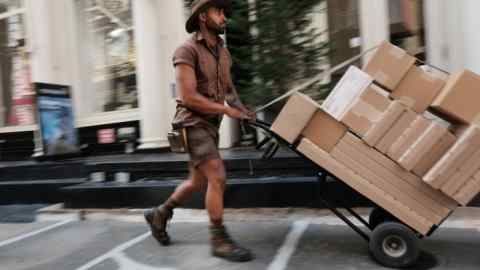 Работник UPS доставляет пакеты в своих ежедневных раундах в Нью -Йорке