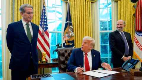 Президент Дональд Трамп окружен министром финансов Скоттом Бессентом справа и министром торговли Говардом Лутником слева