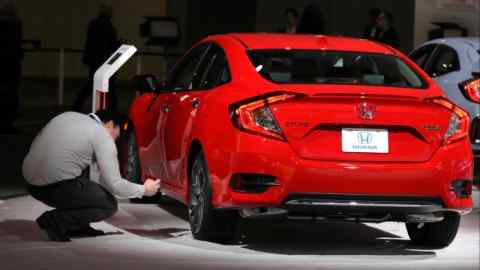 Человек осматривает автомобиль Honda в выставочном зале