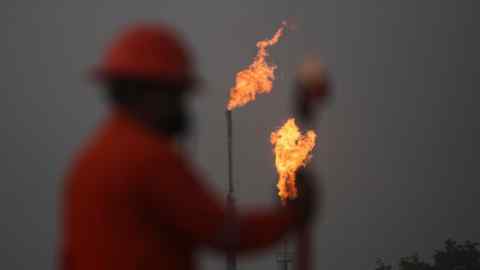 Рабочий PEMEX ходит перед газовыми ракетами