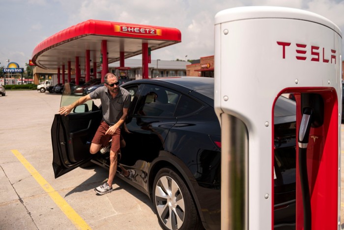 Водитель останавливается, чтобы зарядить автомобиль Tesla на заправочной станции Sheetz в Бризеваде, штат Пенсильвания, США