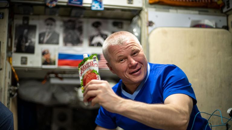 Roscosmos Cosmonaut Oleg Navitskiy демонстрирует сумку для напитков во время полуденного приема пищи на международной космической станции в 2021 году. Файл Pic: НАСА