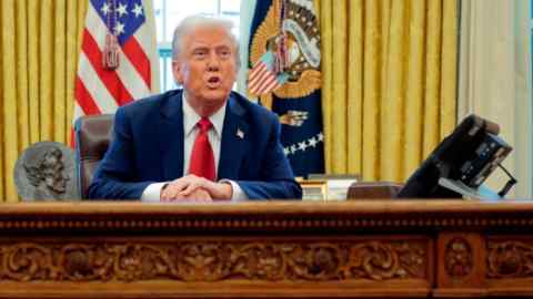 Президент Дональд Трамп сидит за решающим столом