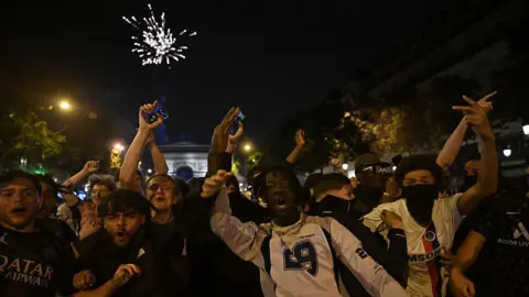 Getty Images Группа празднования футбольных фанатов с Arc de Triomphe, видимой на заднем плане