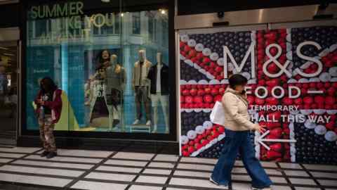 Человек проходит мимо продовольственной магазина M & S
