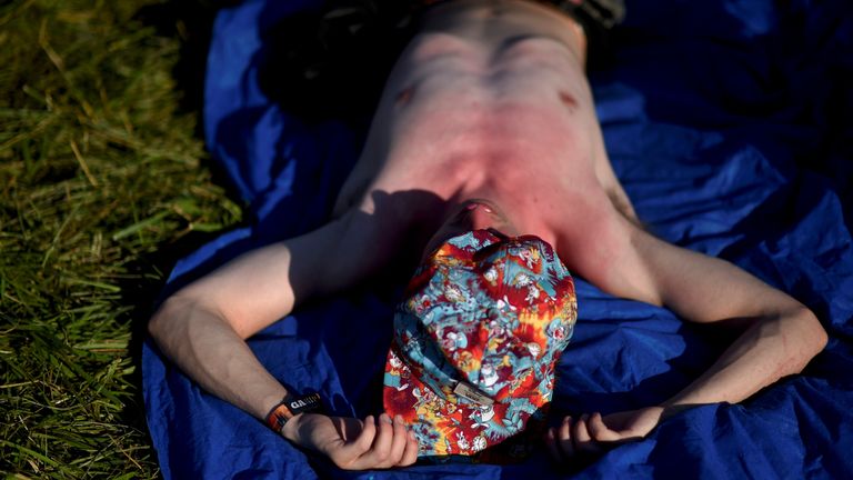 Солнечный человек лежит на траве. Файл фото: Reuters