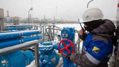 Работник регулирует конвейер -клапан на станции компрессора Gazprom, начальная точка газопровода Nord Stream 2