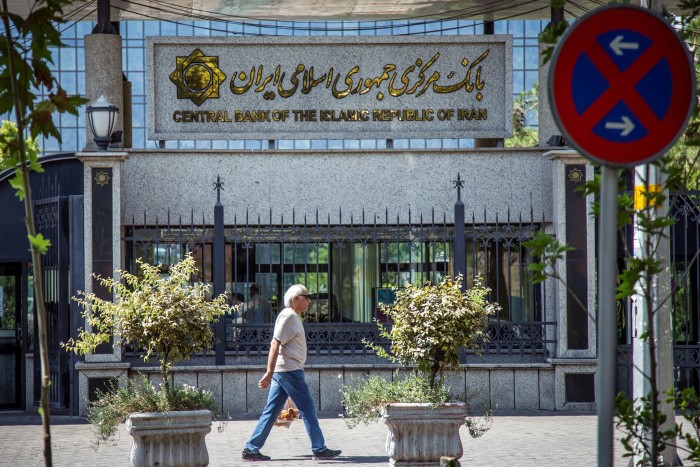 Человек проходит мимо центрального банка Ирана в Тегеране