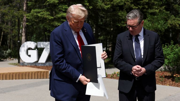 Президент США Дональд Трамп имеет подписанное торговое соглашение в Великобритании и США во время встречи с премьер-министром Великобритании Кейром Стармером на саммите G7, в Кананаскисе, Альберта, в понедельник, 16 июня 2025 года. (Сюзанна Планкетт/Pool Photo через AP)